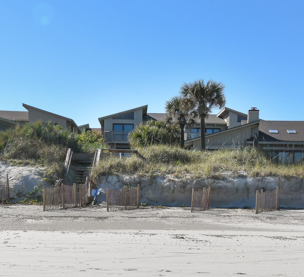sandy beach with luxurious house in background