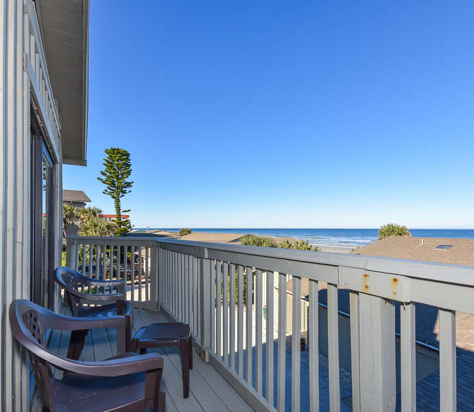 Long balcony with outdoor seating overlooking beach