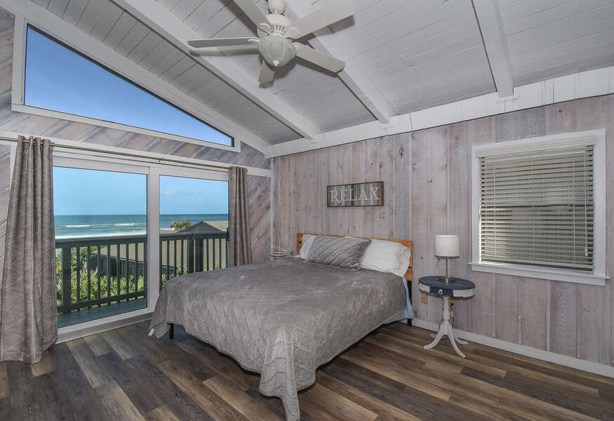 Spacious bedroom with wood floor and ocean view