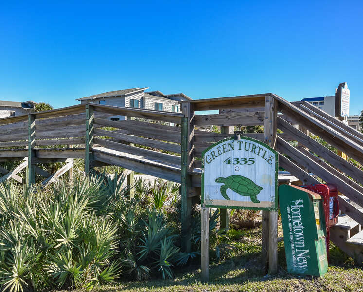 Green Turtle Entrance sign with wooden walkway