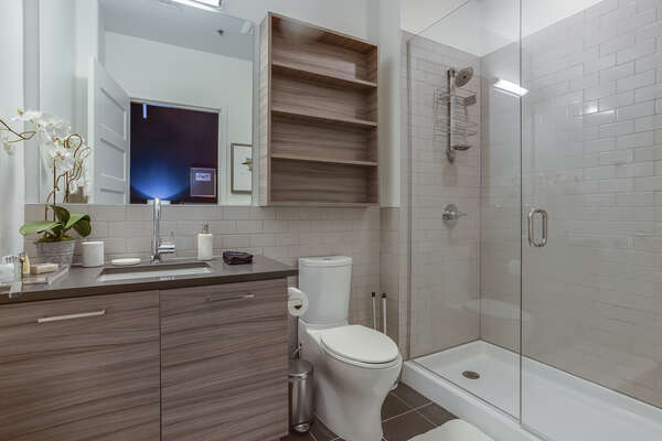 Master Bathroom of this Apartment Near Ponce City Market with vanity sink, toilet, and walk-in shower.