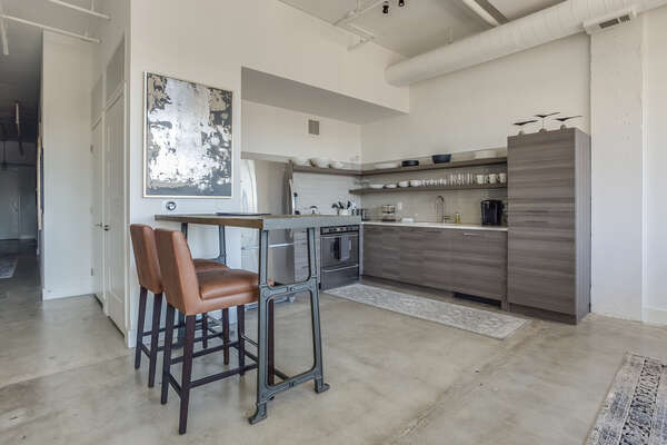 Kitchen of this Apartment Near Ponce City Market with modern appliances and small table with two chairs.