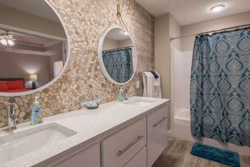 Beautiful bathroom complimented with a stone wall backdrop connected to dual sinks is attached to the master bedroom on 2nd floor