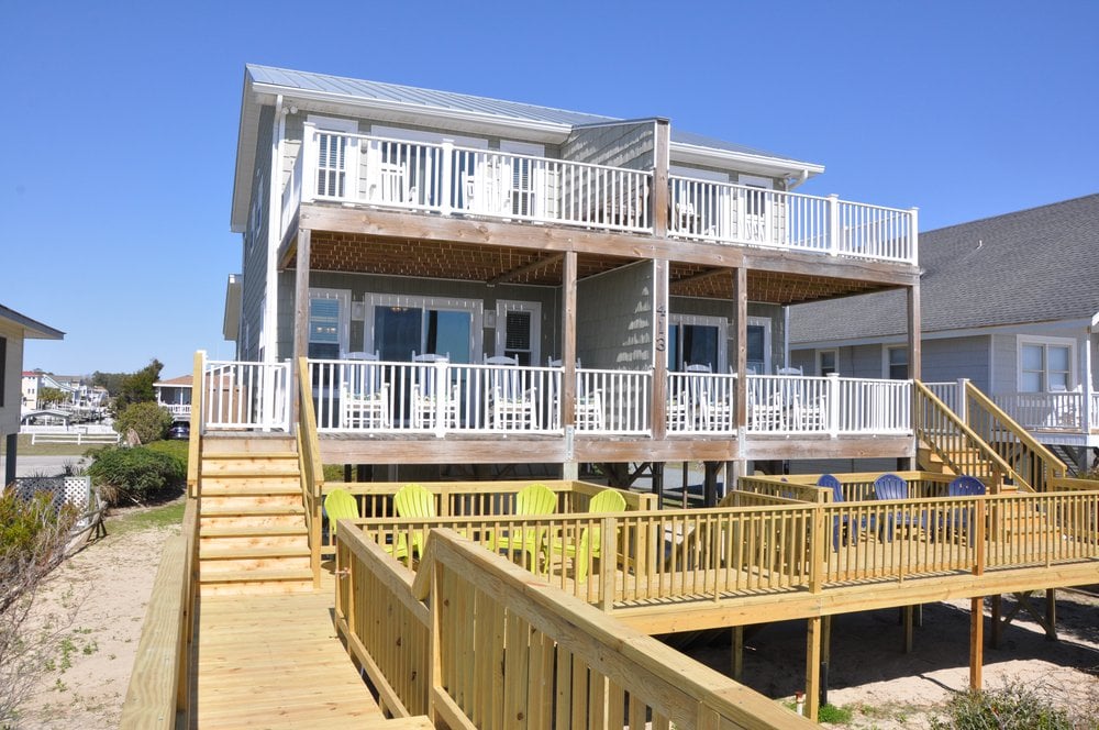 A vacation rental house with a deck and chairs in Holden Beach.