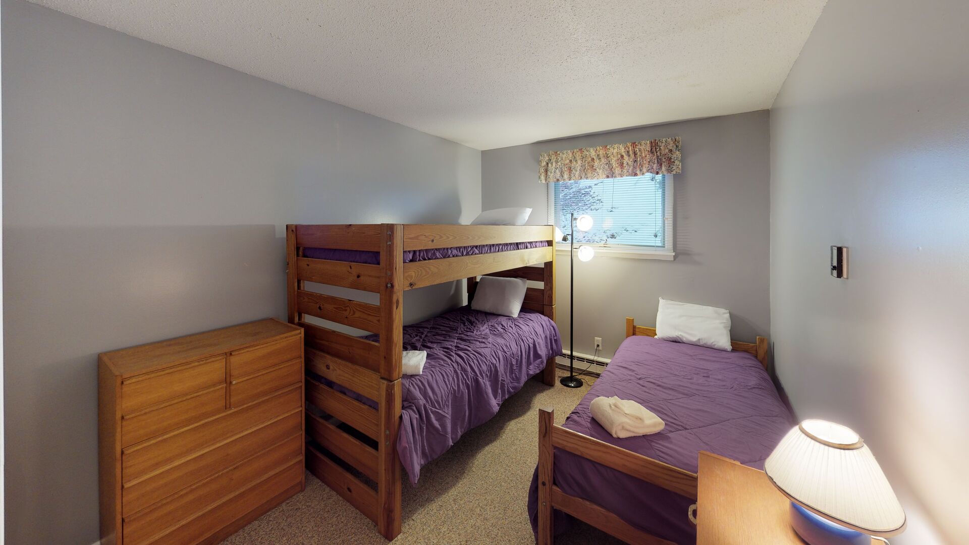 Lower level bedroom with one set of twin bunks and one twin bed