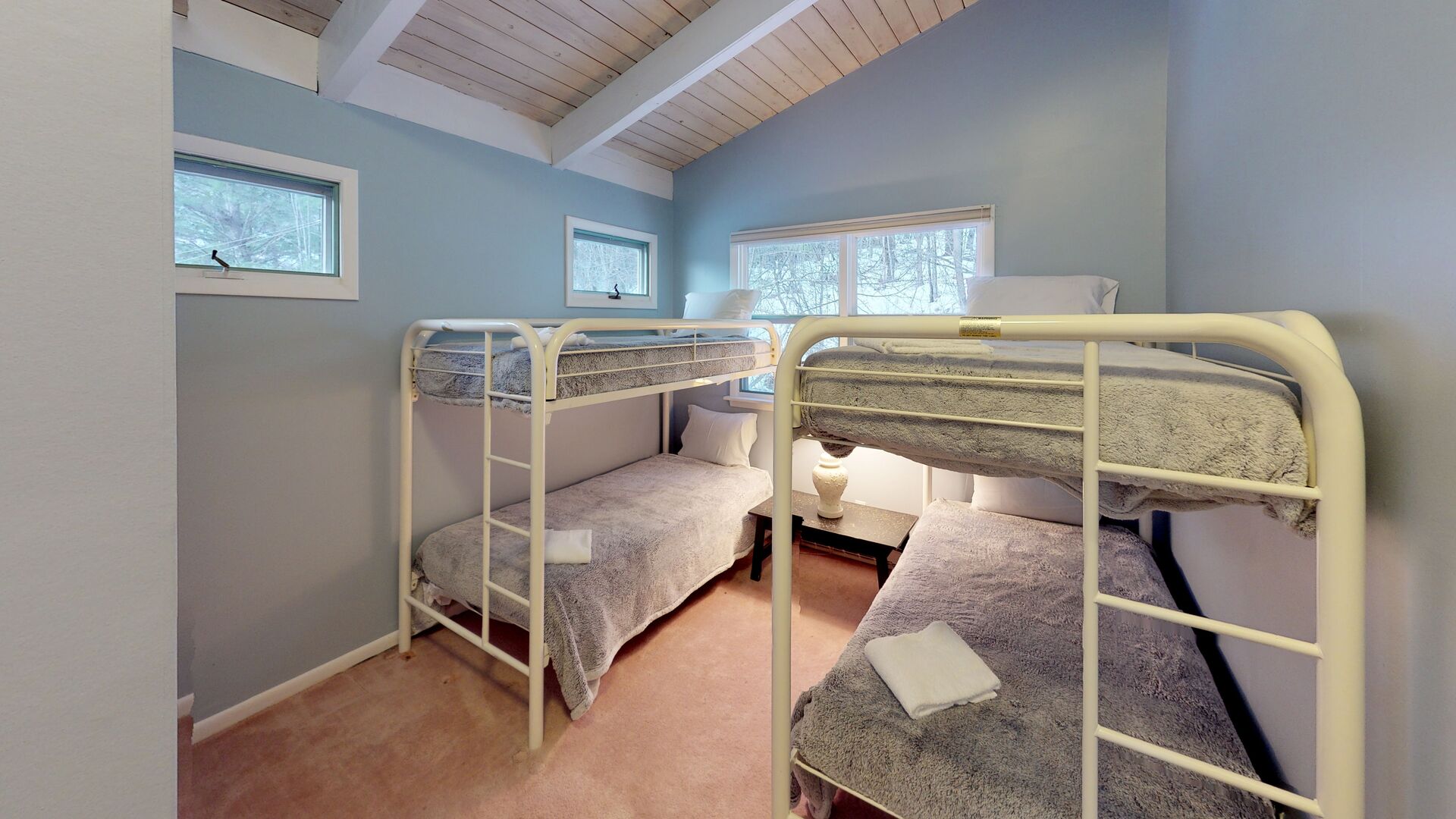 Upper level bedroom with two sets of twin bunks beds.