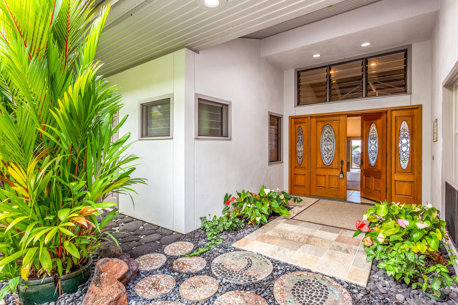 Native Hawaiian plants and flowers surround the entry.