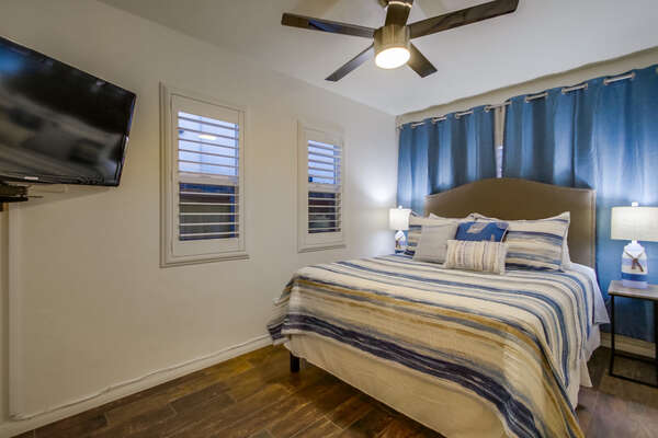 Bedroom with Large Bed, TV, and Ceiling Fan.