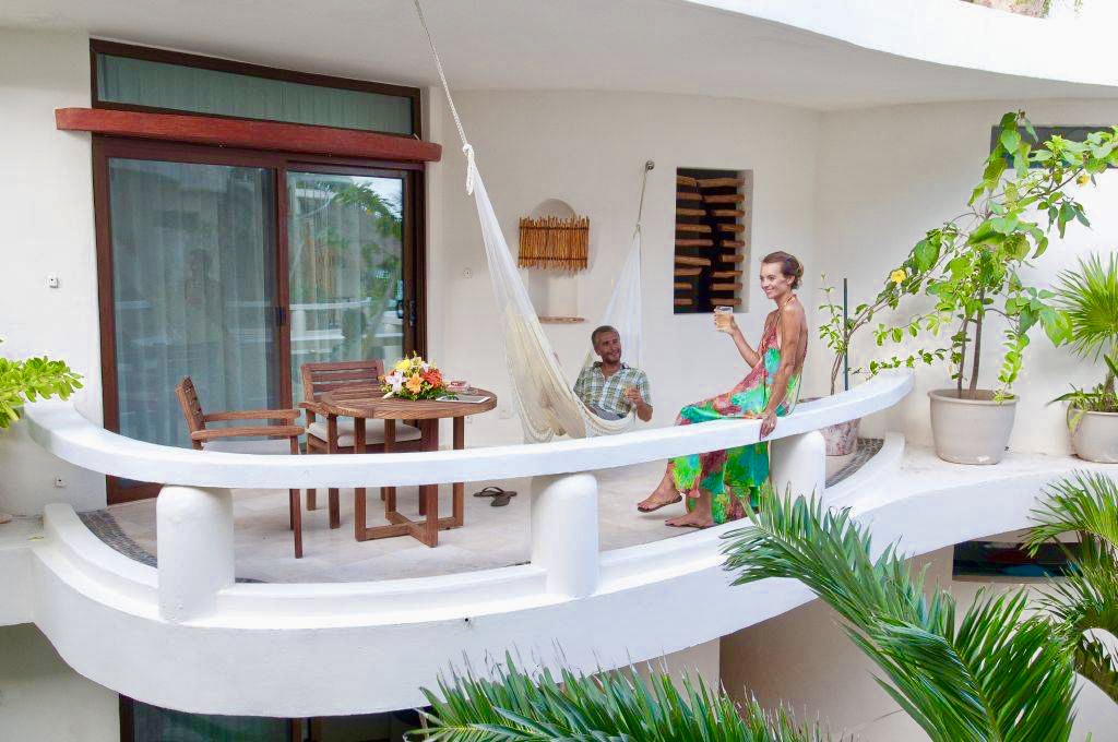 Large private balcony with chairs and hammock.