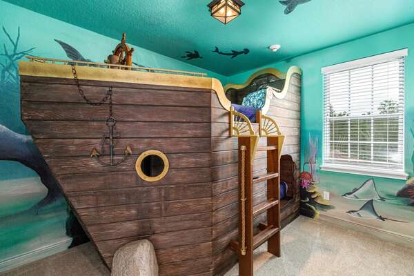 Little pirates will love this fun bedroom with a pirate ship bed and under the sea artwork
