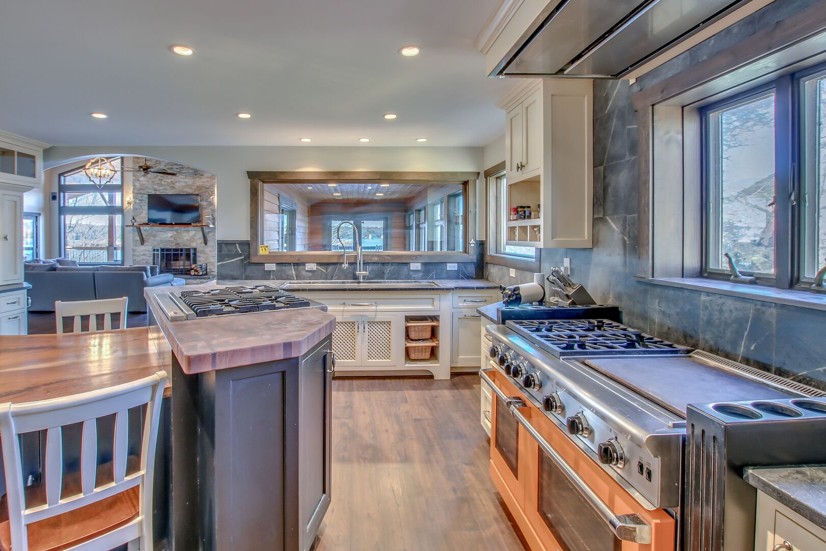 The large oven, island stove top, and sink of the kitchen in this Poconos rental by the lake.
