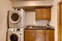 The laundry has a full size stackable washer and dryer. There is as sink, iron and ironing board.