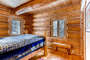 This cute bedroom on the main floor has exposed logs and cute cabin decor.