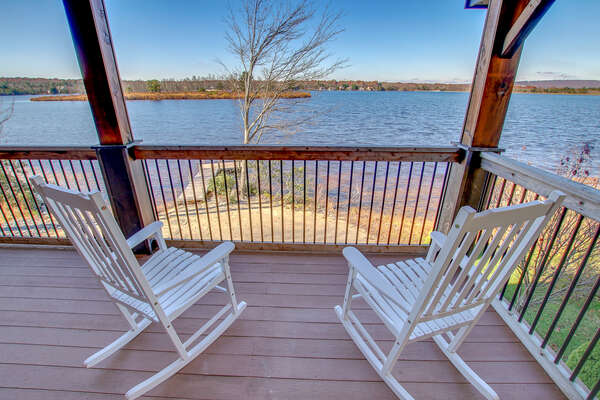 Two rocking chairs facing the lake on the porch of this Poconos rental by the lake.