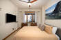 Master bedroom with ceiling fan and TV