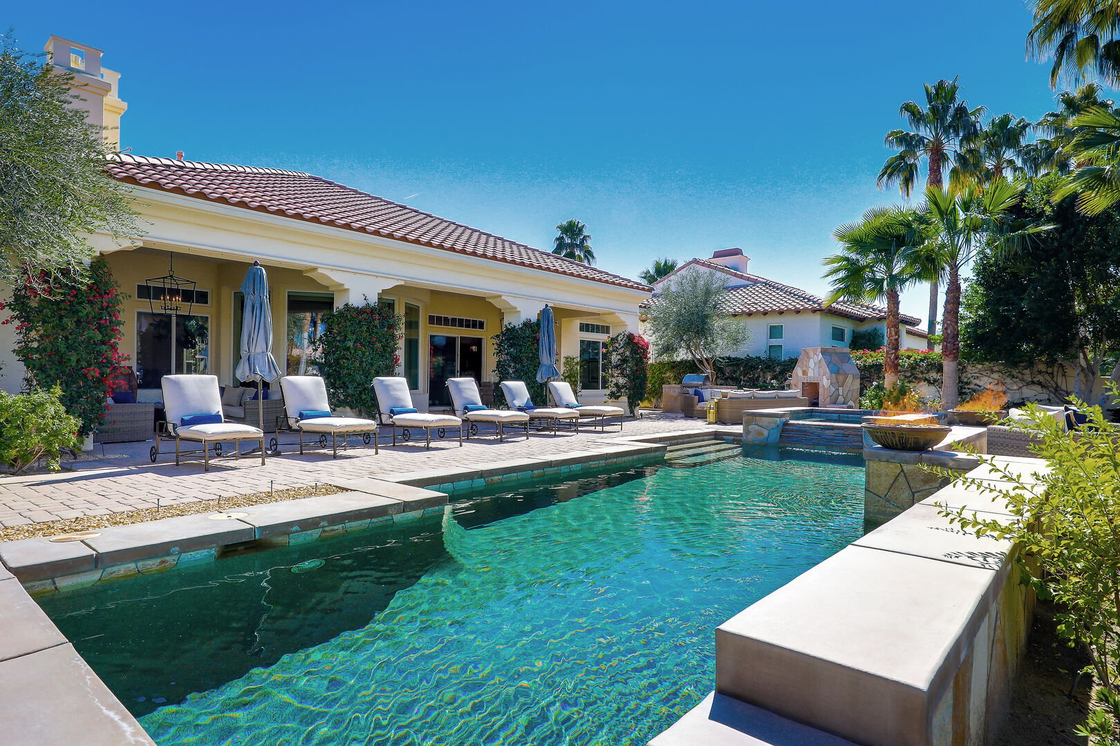 Private, resort-style backyard with fireplace, custom BBQ island, ample seating and al fresco dining.