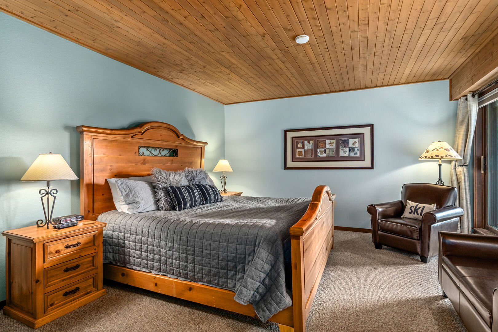 A king bed with large wood frame centers the primary bedroom suite