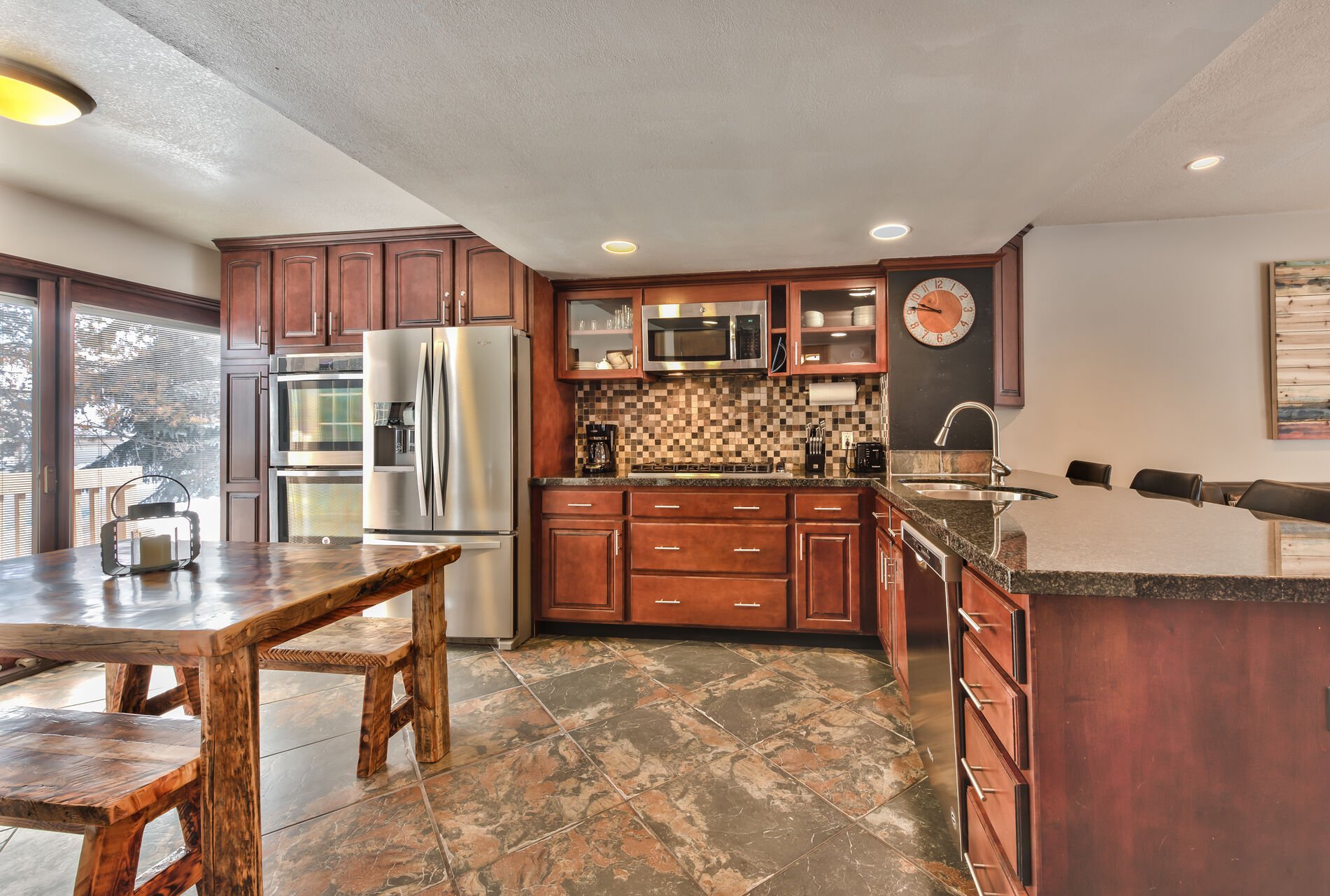Fully Equipped Kitchen with New Stainless Steel Appliances and Granite Counters, and Dining Table with Bench Seating