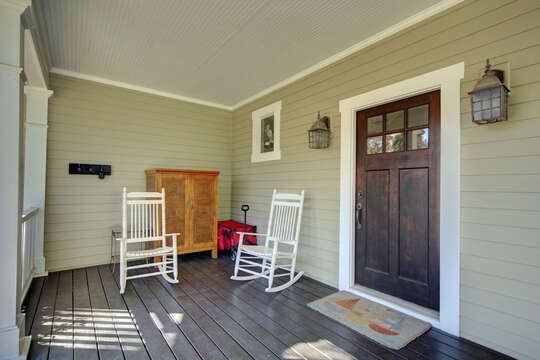 The front porch, complete with storage and two armchairs.