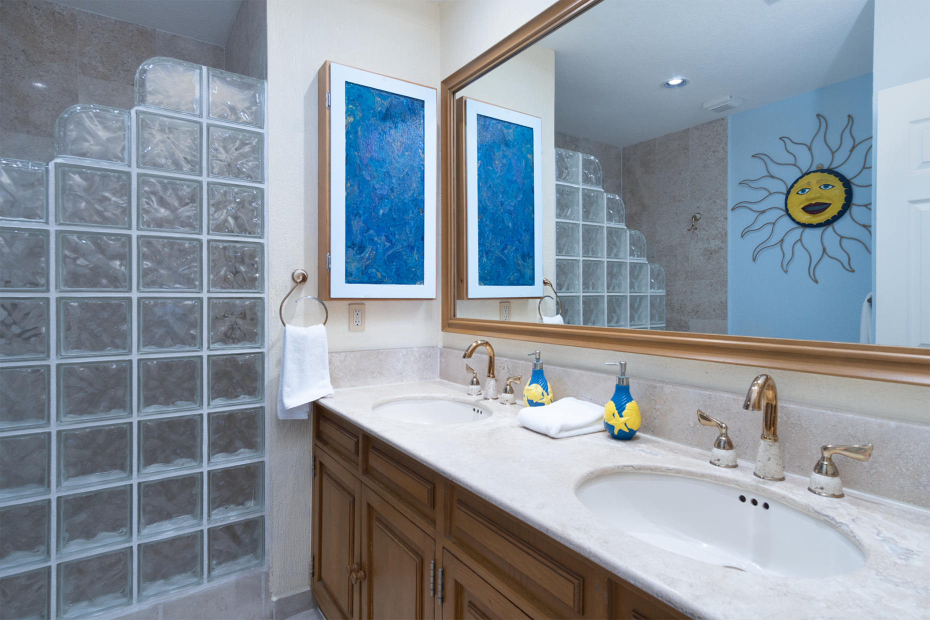 The main bathroom has smart glass blocks around the shower, and a double vanity sink area.