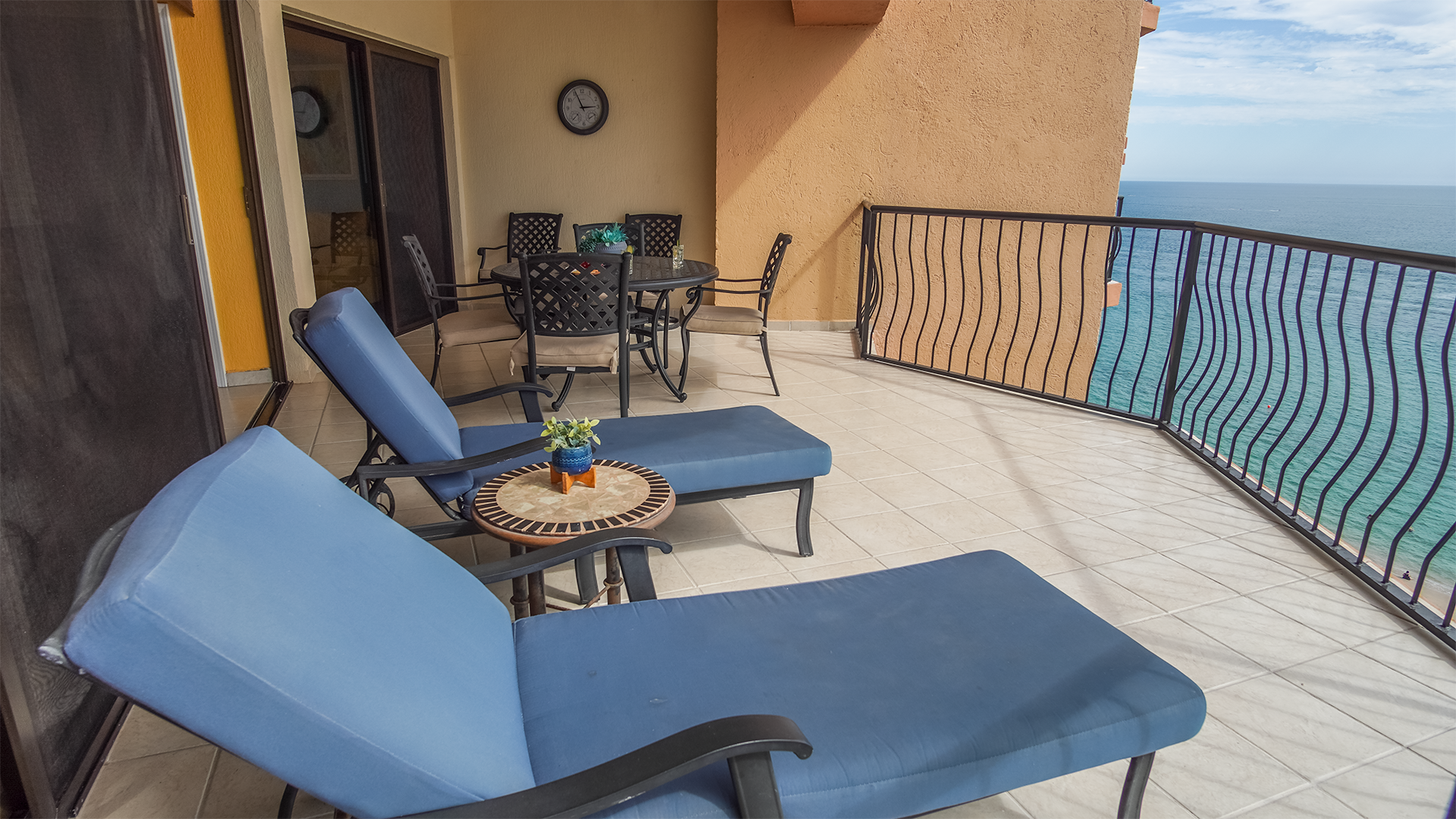 Two chaise lounge chairs, and a dining table on the patio.