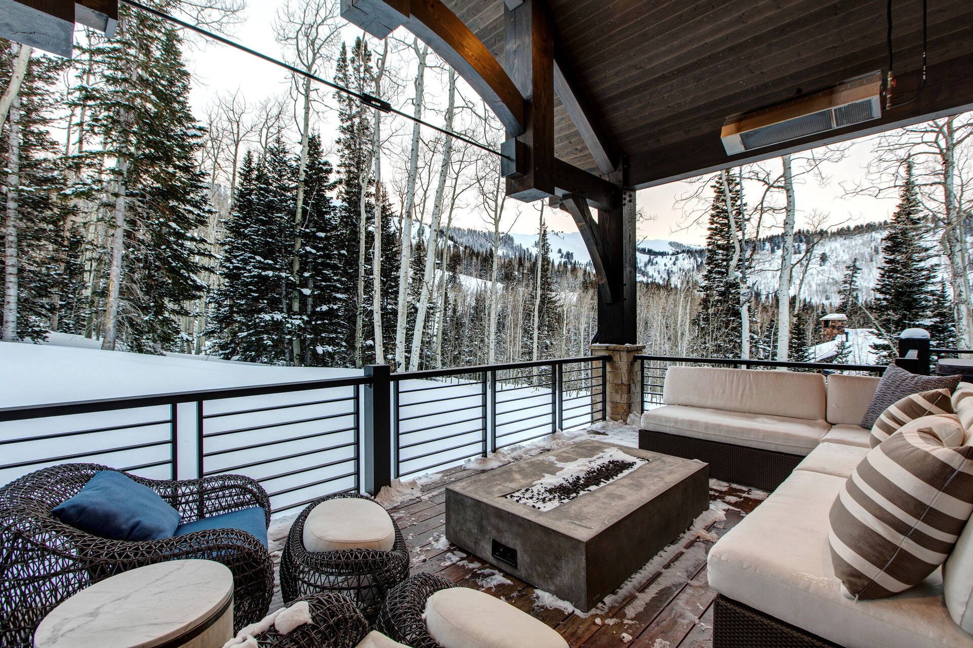 Covered Deck with an Abundance of Outdoor Furniture, including a Fire Table, and Commercial Heaters