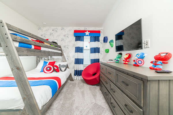 An upstairs bedroom with a twin/full bunk bed with some super decorations