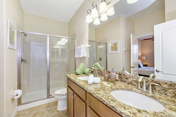 The bathroom has a walk-in shower and dual vanity