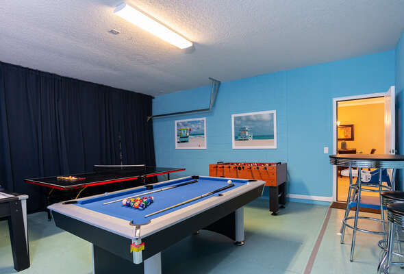 games room with pool, ping pong, foosball and air hockey and pub  style table with 2 stools