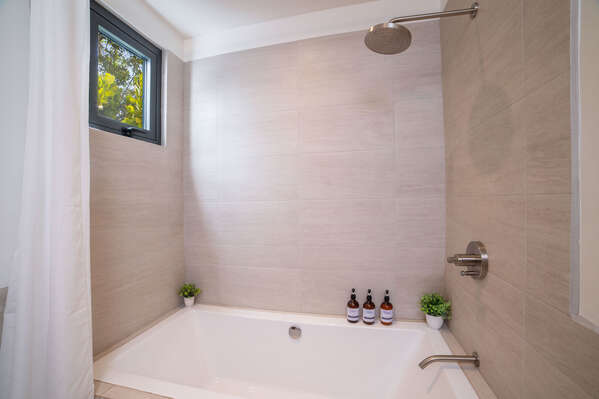 The guest bathroom is equipped with both a tub and shower, perfect for a quick rinse or a relaxing soak.