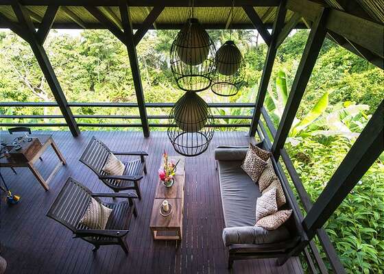 A second floor terrace overlooks the living area and jungle foliage