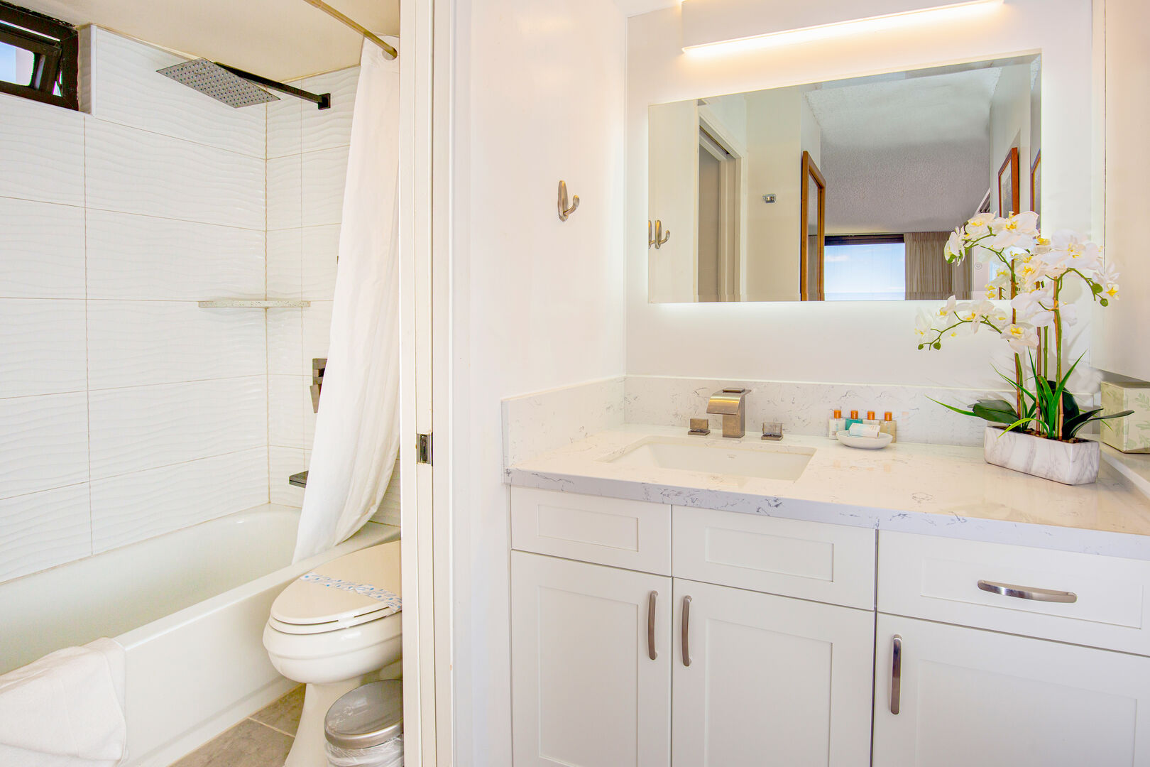 Bathroom with tub and shower combo. Sliding door separates the toilet and sink