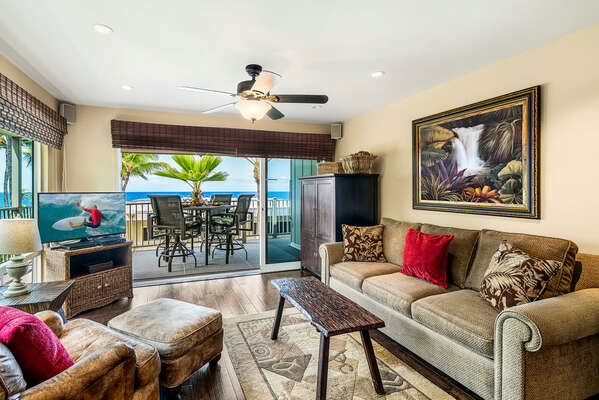 Sofa, armchair, ceiling fan, smart TV, and sliding doors to the oceanfront lanai