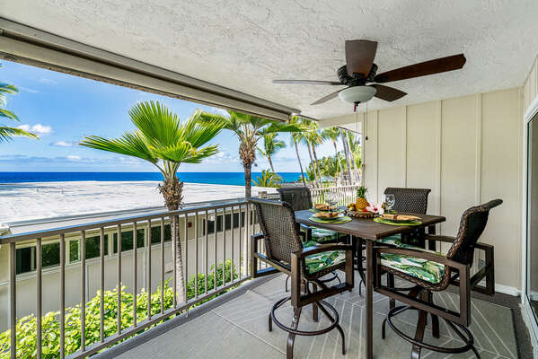 Covered lanai with table, chairs, and ceiling fan in our ocean front condo