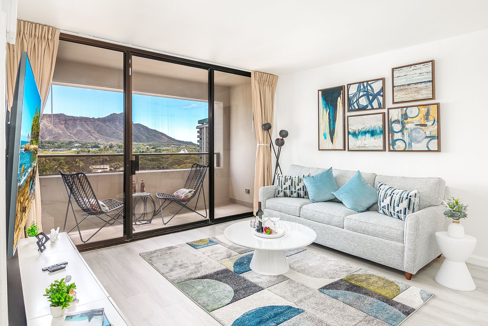 Your living area has a pull-out sleeper sofa, a coffee table, a 65'' Samsung Smart TV, and a Diamond Head view.