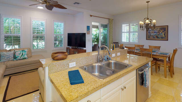 Kitchen island with nearby televise, couches and table