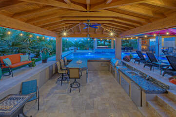The backyard oasis includes a pool bar, large grill, fridge/freezer, dishwasher and cozy furniture for relaxing and dining poolside.