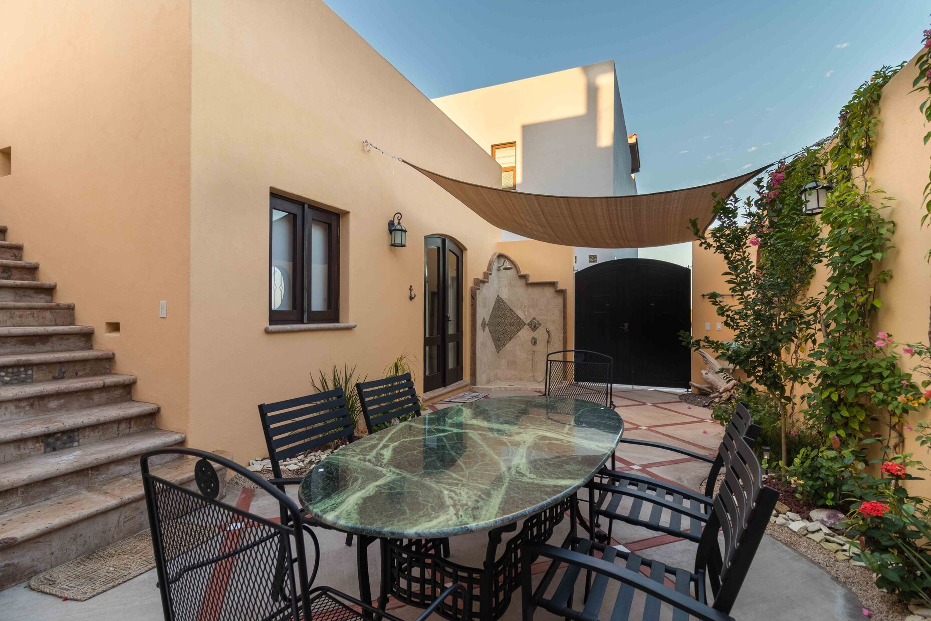 Outdoor shower, and double rear gates for access to the beach and community plaza next door.