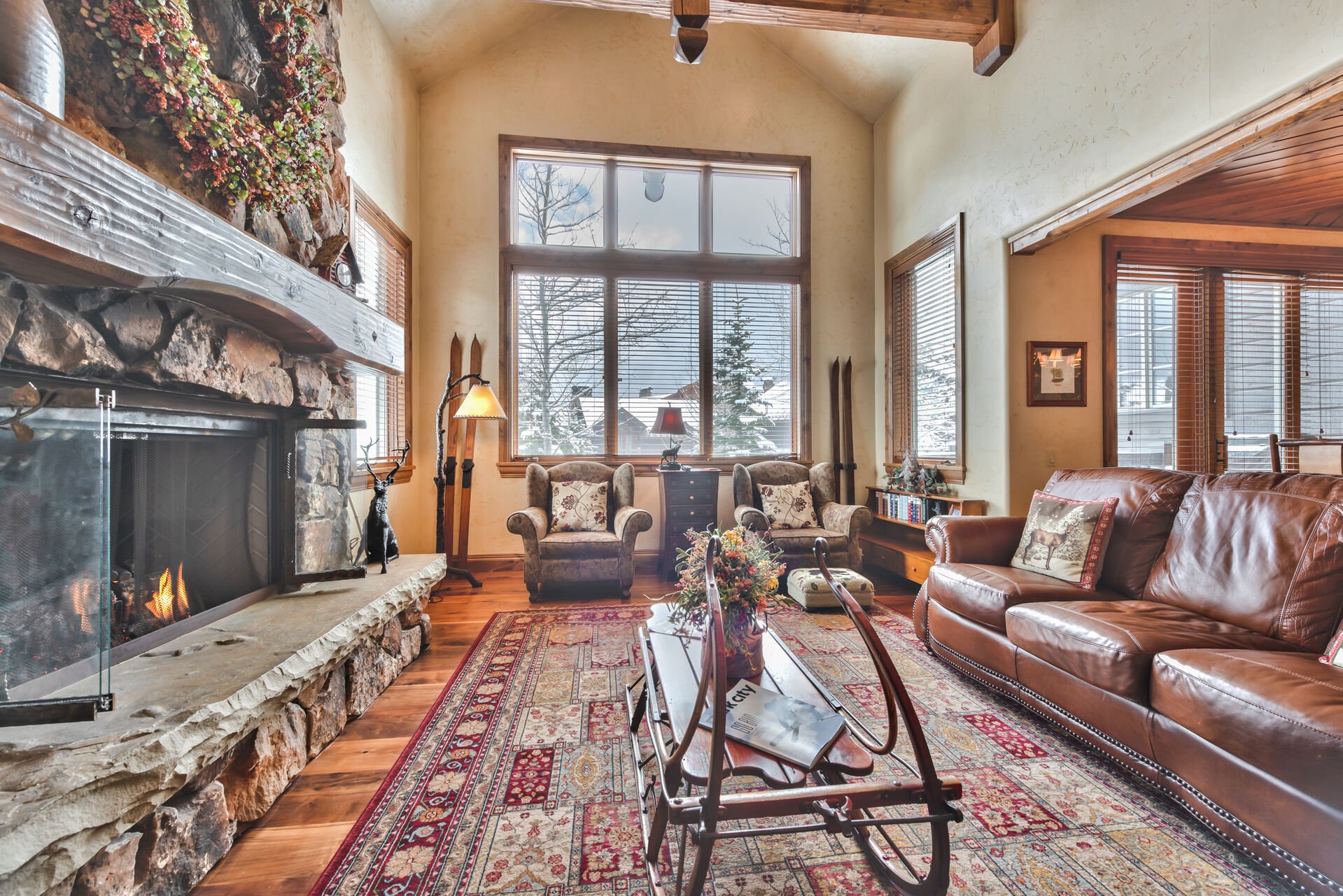Main Level Living Room with Cozy Mountain Furnishings, Vaulted Ceilings, Warm Gas Fireplace, and Large Windows for Natural Light