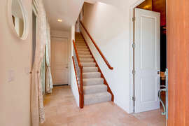 Stairs leading to upper level from front door.  Downstairs bedroom door to the right and laundry to the left.