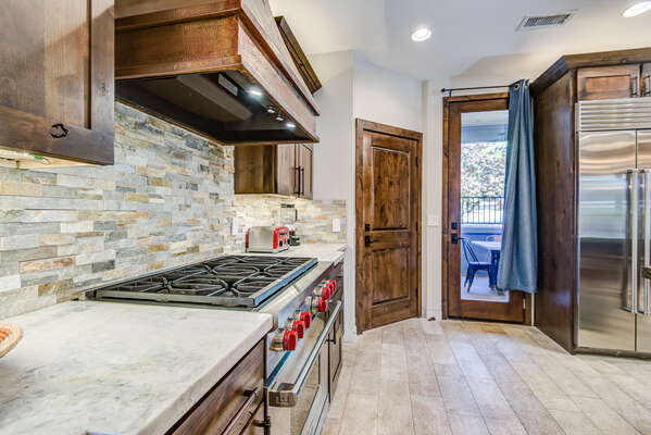 Gourmet Kitchen with Stainless Steel Appliances, including a Wolf 6-Burner Gas Range and Front Patio Access