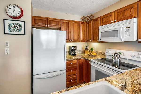 Kitchen with appliances like fridge and microwave.