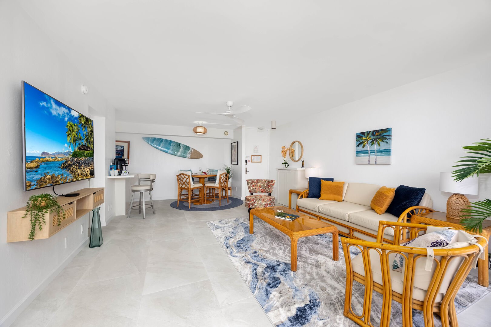 The living room has a pull-out sleeper sofa, coffee table, chairs, and flat-screen TV.