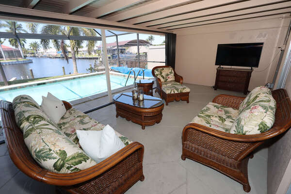 Lanai seating area with flat screen TV, pool and view