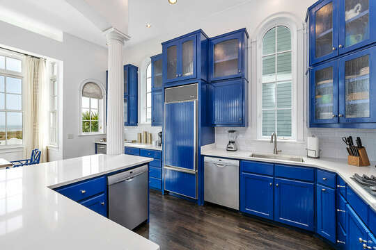 The eye-catching Kitchen features plenty of storage and bright white countertops.