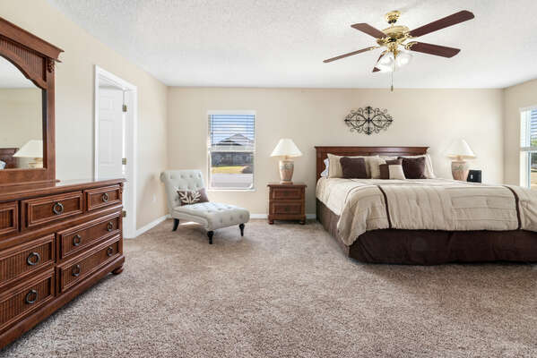 alternate of master bedroom with king bed and accent chair