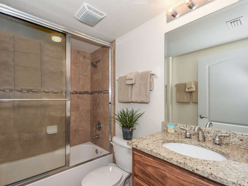 Bathroom with shower-tub combo, single vanity sink, and toilet
