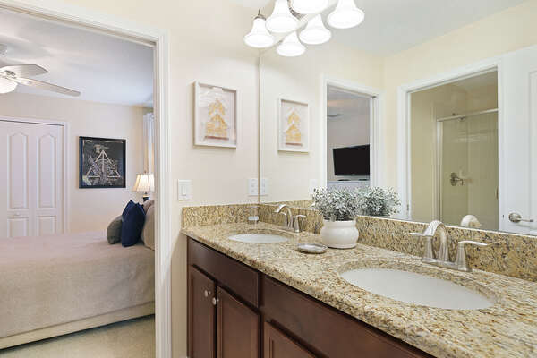 The ensuite bathroom features a dual vanity and shower/tub combination