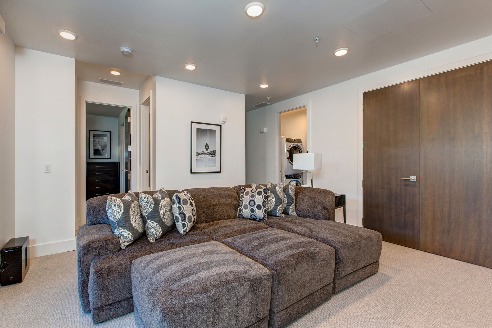 Lower Level Family Room with a Comfortable Sectional Sofa and Ottomans