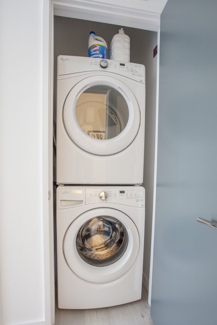 The laundry Area Features a Stacked Washer and Dryer.